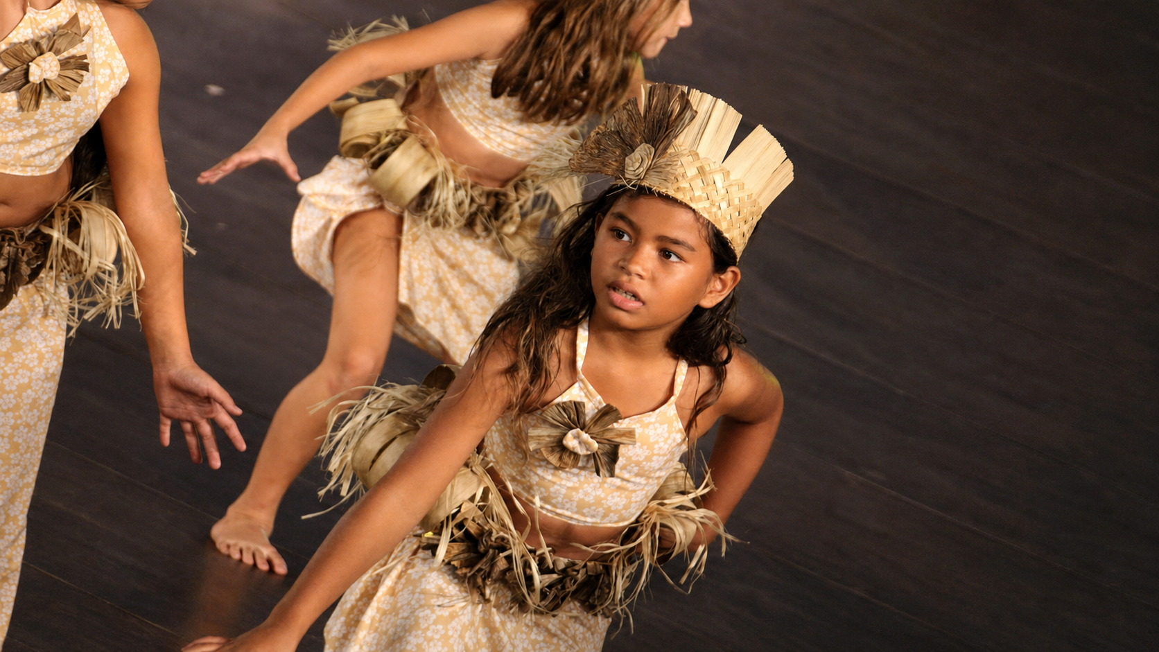 Jeunes danseuses de 'Ori Tahiti en costume végétal sur scène
