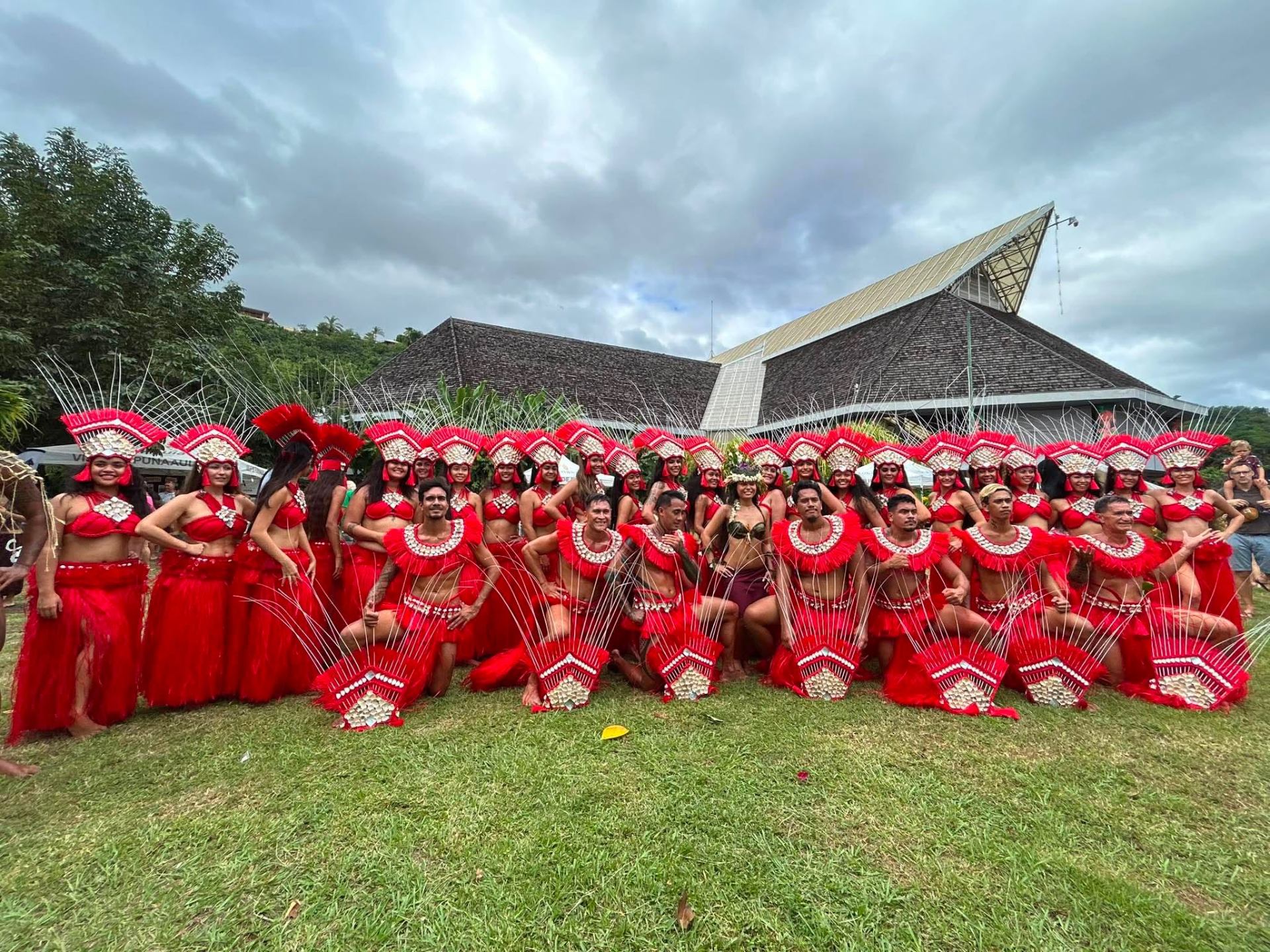Photo de groupe du troupe Temaeva en costume rouge après la représentation